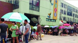 金壇市實(shí)驗(yàn)幼兒園門前，家長(zhǎng)在排隊(duì)