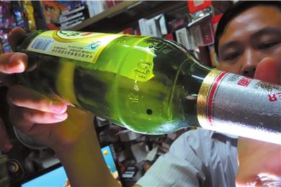 這瓶未開封的燕京啤酒內有一顆黑色懸浮物。京華時報記者 徐曉帆 攝