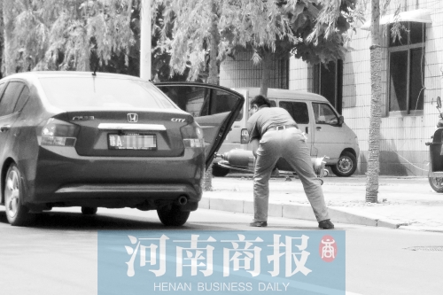 鄭州西區(qū)一氧氣廠門前，有人充氣后，將氧氣瓶裝上私家車運走