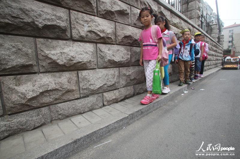 2013年09月11日，濟(jì)南運署街上，小學(xué)生走史上“最窄人行道”上學(xué)。圖片來源：CFP