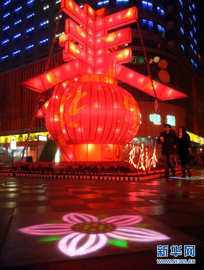 　1月30日晚，市民從蘇州市石路銀河廣場上大型“春”字彩燈景觀旁經(jīng)過。