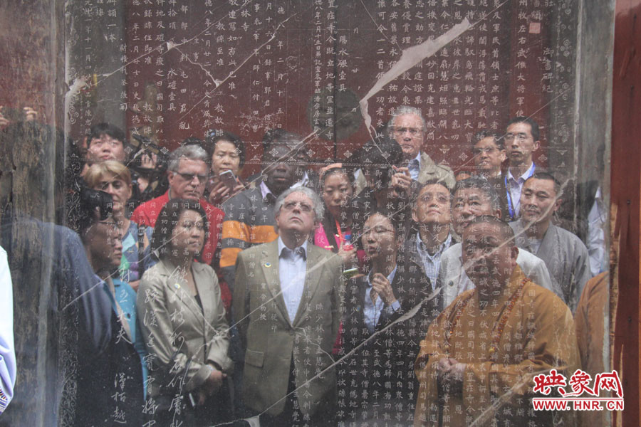 在一塊石碑前，少林寺方丈正在講解