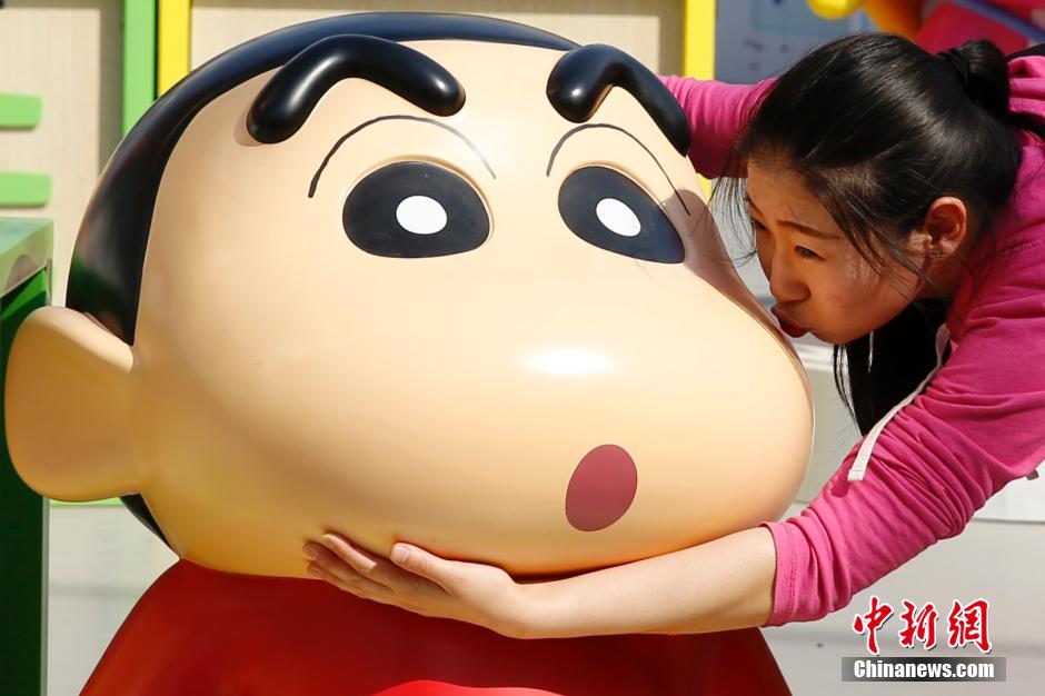 4月22日，游客與蠟筆小新合影。“蠟筆小新25周年紀(jì)念特展”日前在北京開展，吸引了不少市民游客。