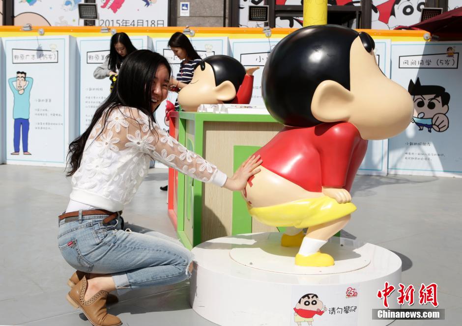 4月22日，游客與蠟筆小新合影?！跋灩P小新25周年紀(jì)念特展”日前在北京開展，吸引了不少市民游客。
