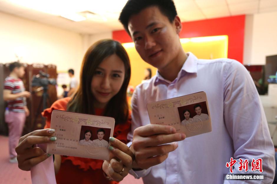5月20日,河南鄭州,一對準(zhǔn)新人領(lǐng)完結(jié)婚證后秀自拍。