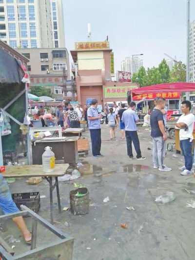 昨天，執(zhí)法人員在京廣路長江路口整治“僵尸圍擋”及圍擋內(nèi)的攤販。