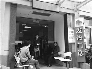 到浙大一院發(fā)熱門診就診的病人增多，不少人在門口等候