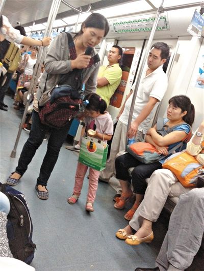 6月27日，舒馨帶一女孩在地鐵十號線行乞。她因被疑帶多個(gè)不同小孩乞討被警方搜尋。新京報(bào)記者 申志民 攝