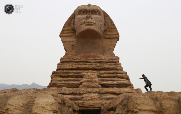石家莊郊外，一名男子與山寨版獅身人面像合影留念。