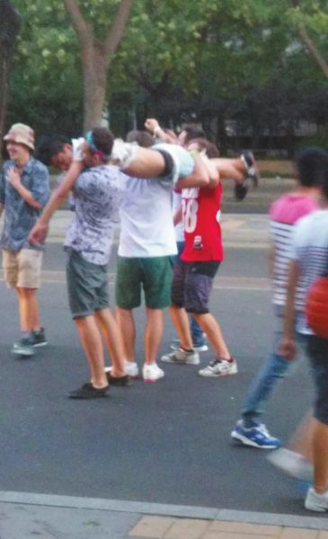 　四名外籍男子一同扛起醉漢拍照。