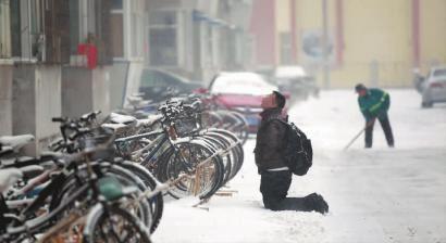 小伙子跪在樓前，一直抬頭看著樓上。 孫立國(guó)/攝