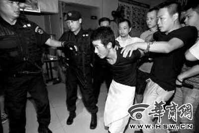 犯罪嫌疑人韓牙某圍著圍裙在廚房?jī)?nèi)拉面，被民警抓獲 本報(bào)記者 鄧小衛(wèi) 攝