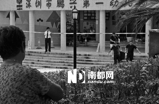 →7月19日，鵬興花園第一幼兒園門前，民警在現(xiàn)場(chǎng)進(jìn)行完勘查取證后，園長(zhǎng)和保安的尸體被運(yùn)走。南都記者 徐文閣 攝