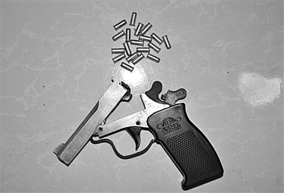 警方從搶劫嫌疑人處起獲的贓款和發(fā)令槍、子彈。警方供圖