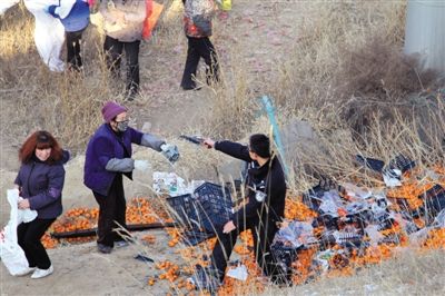 1月4日，連霍高速蘭州市榆中縣和平鎮(zhèn)段，一名警察舉著槍驅(qū)散哄搶橘子的村民。圖/CFP