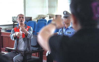 張志國在法庭上用手語回答提問。記者 蒲東峰攝