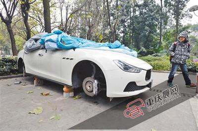 昨日，停放在重慶大學(xué)B區(qū)的一輛瑪莎拉蒂豪車被架在幾塊磚頭上，車輪不翼而飛。 重慶晨報(bào)記者 胡杰 攝