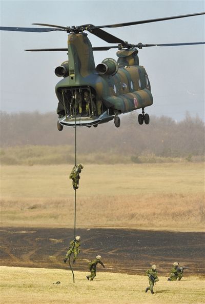 “登島” 1月13日，位于東京的習(xí)志野市，日本自衛(wèi)隊隊員在新年軍演中演練直升機登島行動。