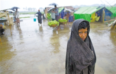 5月14日，緬甸若開邦實(shí)兌難民營，羅興亞族難民在雨中行走。熱帶風(fēng)暴“馬哈森”即將登陸緬甸，這里的難民開始乘船撤離。