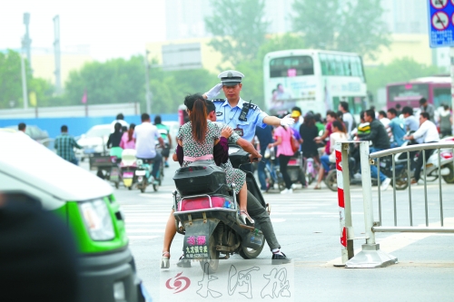 鄭州市交巡警五大隊民警楊華民正帶領他的同事在路口執(zhí)勤