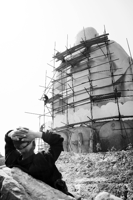 今年4月26日，工作人員將帆布蓋在“佛像”頭像上