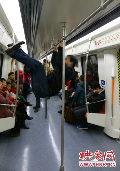 地鐵試乘日，一男子在車廂內(nèi)攀爬扶手自?shī)首詷?lè)