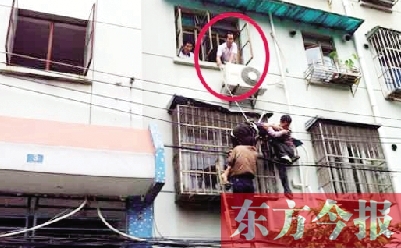施救現(xiàn)場，劉鵬（圈內）先用繩子捆住老太確保安全 勞動報記者 郭娜 供圖