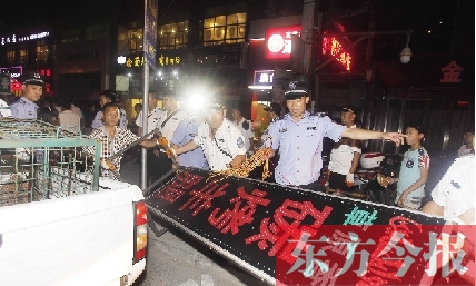 7月8日晚，鄭州市商城路一家占道經營的攤販招牌被執(zhí)法隊員“登記保存”
