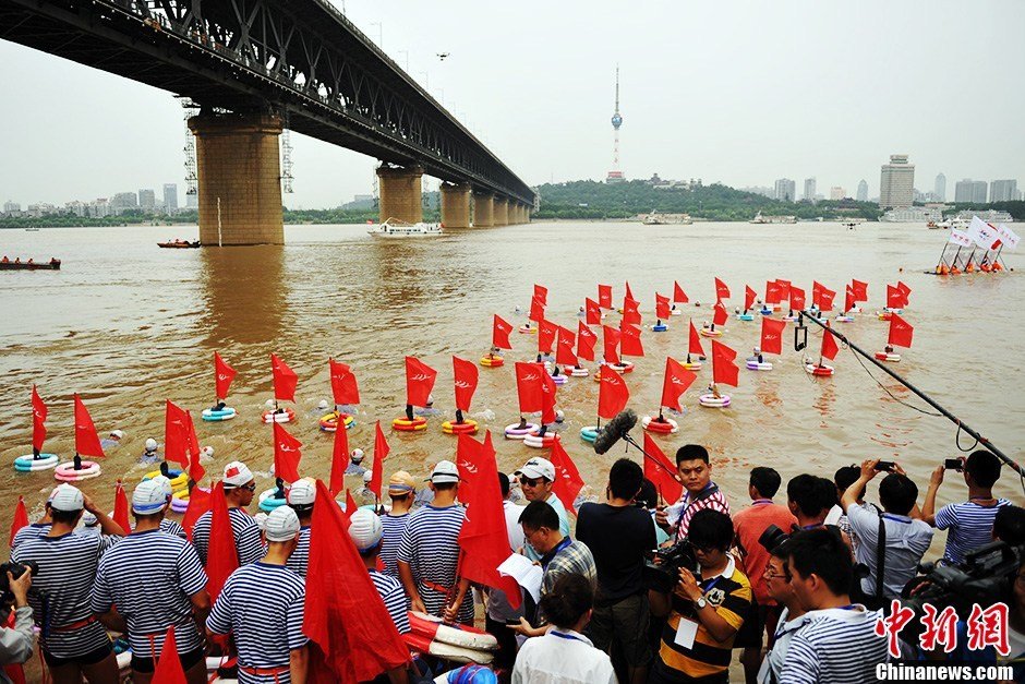 圖為江面上的橫渡方隊(duì)里的選手們劈波斬浪。中新社發(fā) 張暢 攝