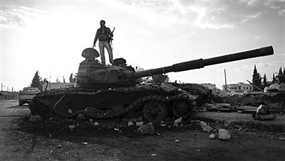 9月8日，敘利亞Zabadani，一名敘利亞反對派武裝人員站在廢棄的政府軍坦克上。
