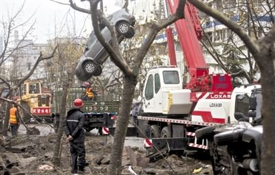 輸油管道爆炸后，搶修人員將被炸毀的車輛運(yùn)出現(xiàn)場(chǎng)。