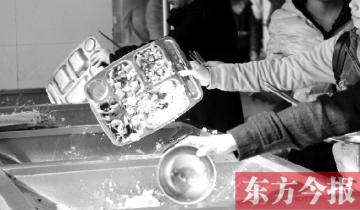 11月27日，河南中醫(yī)學(xué)院餐廳，一名同學(xué)將餐盤內(nèi)沒吃完的食物倒入餐具回收車內(nèi)