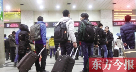 鄭州火車站東廣場售票大廳，幾名學(xué)生在售票窗口前躊躇