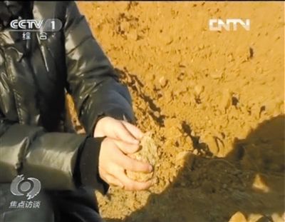 麻剛沙系麻剛石粉碎而成。記者找到一塊麻剛石，一捏就碎成粉末，硬度非常差。央視截圖