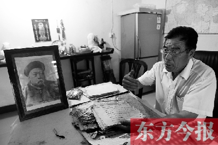 　魏樹紹手拿《物權(quán)法講義》手稿，在講訴先祖書寫“物權(quán)法”的歷史（相框里就是魏聯(lián)奎）