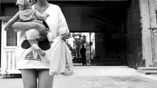 抱著孩子出售人奶的女子。