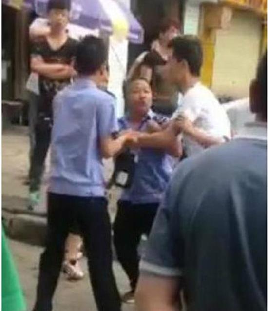 付某（右）與城管執(zhí)法人員廝打在一起。
