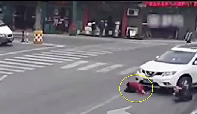 圖為小姑娘被卷進(jìn)車輪下瞬間。
