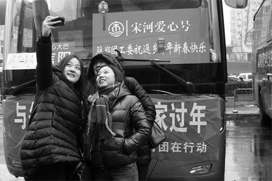 昨天上午8時(shí)，鄭州正道中環(huán)百貨廣場(chǎng)，準(zhǔn)備回家的老鄉(xiāng)在愛(ài)心大巴車前合影留念