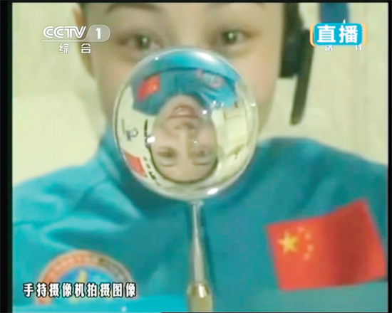 王亞平的倒影出現(xiàn)在水球中。新華社發(fā)（視頻截圖）