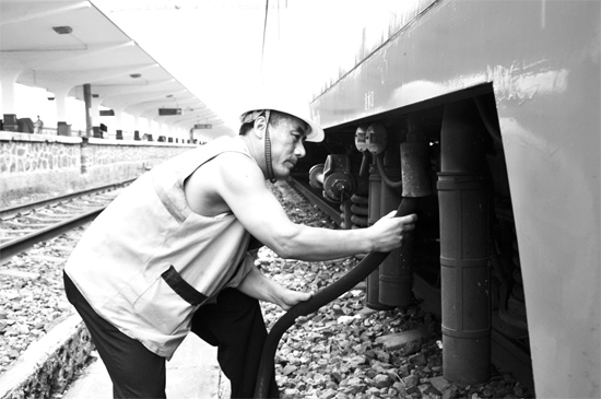 昨日，商丘火車站給水員在烈日下工作