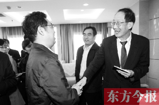 崔琦先生握手東方今報記者靳暉，感謝他把照片珍藏了15年