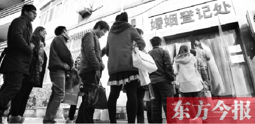 昨日，鄭州市中原區(qū)婚姻登記處等待“領證”的情侶們將隊伍延伸至辦事大廳大門外