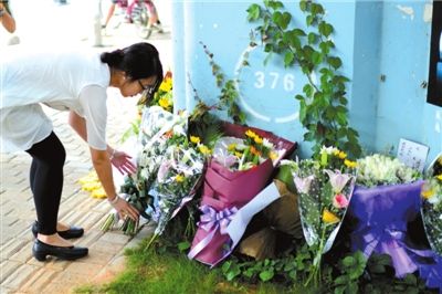 6月8日下午，記者來到廈門公交車爆炸事發(fā)現(xiàn)場橋下，附近已聚集了十幾個自發(fā)前來悼念的市民。橋墩下排放了一圈或黃或白的菊花，還有玖瑰、百合等。