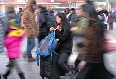 春運(yùn)首日，北京站客流量明顯增多，一名女孩在人流中等待進(jìn)站。