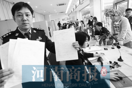 　民警左手拿的是新申請表，右手拿的是三份老申請表 王春勝/攝