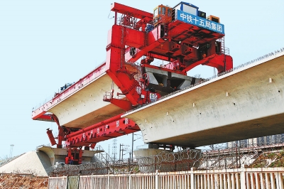 建設(shè)者們操縱巨型起重機(jī)在吊放橋墩。記者鄧放攝
