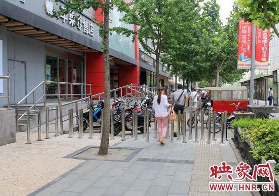 圖中道路左側(cè)的無障礙通道被鋼管隔離,右側(cè)的盲道也被侵占。