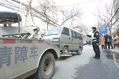 聯(lián)合執(zhí)法人員將市民舉報(bào)的違法占道經(jīng)營車輛拖走暫扣