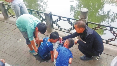 男孩被救出后，圍觀群眾幫他控水換衣服。